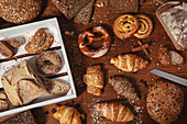 Hausgemachte Brötchen, Brote, Croissants und andere Backwaren auf Holztisch
