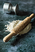 Flour with wooden rolling pin with floral decoration