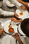 Unrecognizable male chefs putting sauce on top of exquisite dish while working in luxury restaurant