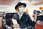 Woman in face mask using smartphone