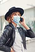 Woman in face mask making phone call