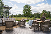 Rattanmöbel auf Holzterrasse mit Landschaftsblick