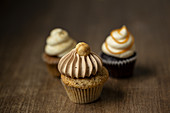 A selection of cupcakes with nuts, caramel and chai-latte cream