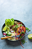 Vegeterian Buddha bowl with lime and peanut slaw, spinach falafels, couscous and salad