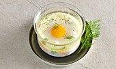 A baked egg with smoked salmon and crème frâiche (oeufs cocotte)
