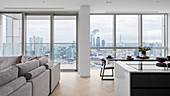 Open living room with large window offering a panoramic view of the city from a high-rise