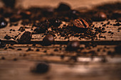Aromatic roasted coffee beans placed on dark wooden table near spread fresh instant ground coffee
