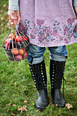 Woman holding a basket with plums