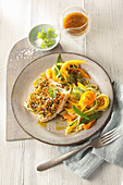 Fish fillet with a herb and orange crust and vegetables noodles