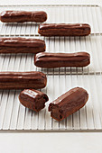 Chocolate eclairs on cooling rack