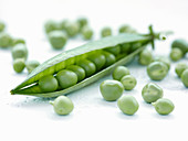 A pea pod surrounded by peas