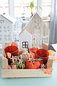 Autumn decorations with knitted pumpkins, lanterns, and wooden houses