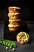 Still life of stacked pea muffins against dark background