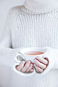 A woman holding a cup of Yogi tea