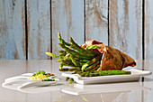 Assortment of plates with chopped vegetables and asparagus with a paper bag full of asparagus