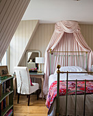 Canopy over metal bed in English-style bedroom