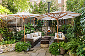 Parasols, chimenea and lounge furniture in cosy courtyard garden
