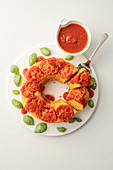 A giant cornbread doughnut with sweet tomato sauce
