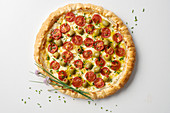 A puff-pastry pizza with cherry tomatoes and stuffed olives