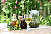 Different tinctures with herbs on a garden table