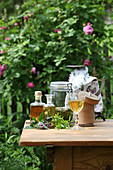 Different tinctures with herbs on a garden table