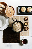 Reis in Schüssel mit Essstäbchen, Sojasauce und getrocknete Nudeln (Asien)