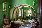 Antiker Sessel in grün gestrichenem Badezimmer mit Rundbogen