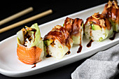 Rolls filled with fresh turnip and garnished with teriyaki sauce