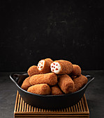 Croquettes served in a bowl on dark background