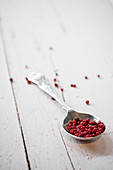 Metal spoon with dried red peppercorns