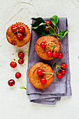 Homemade cherry muffins with sweet cherry on concrete background