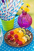 Obststicks in Regenbogenfarben und Strohhalme für eine Party