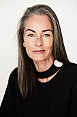 Frau mit grau-melierten Haaren und Halsband in schwarzer Bluse