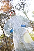 Person in protective suit in forest