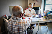 Man in consultation with a GP wearing a surgery mask