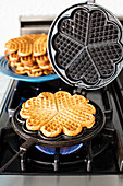 Waffles in waffle maker on gas stove
