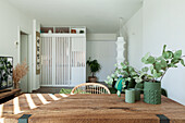 Vase of eucalyptus branches on dining table with wooden top