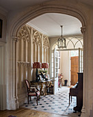 Foyer of historic villa with Gothic Revival stucco and archway