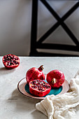 Two whole and a half pomegranate on plate