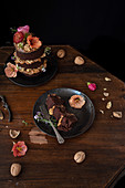 Piece of chocolate naked cake with cream, walnuts and edible flowers