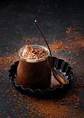 Chocolate mousse in glass jar with chocolate powder dust