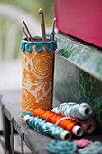 Tin can covered with wrapping paper and crocheted trim used to hold crochet hooks