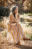 A grey-haired woman wearing a striped dress