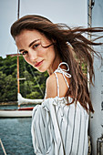 A brunette woman wearing a summer dress on a boat