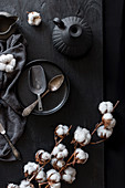 Retro spoons on plate with tender cotton flowers
