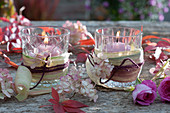 Gläser umwickelt mit Maisblättern als Windlichter, Hortensienblüten, Rosen und Herbstlaub als Deko