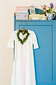 Nostalgic nightgown and a heart-shaped wreath on blue cupboard