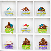 Cupcakes with colorful cupcake liners and sugar flowers in a box display