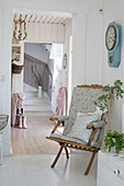 Folding chair with floral upholstery in shabby-chic hallway