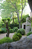 Buchsbaumkugeln im Garten mit Kiesbett ums Natursteinhaus